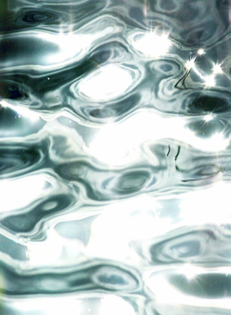 Wasseroberfläche mit Lichtspiegelung und leichten Wellen